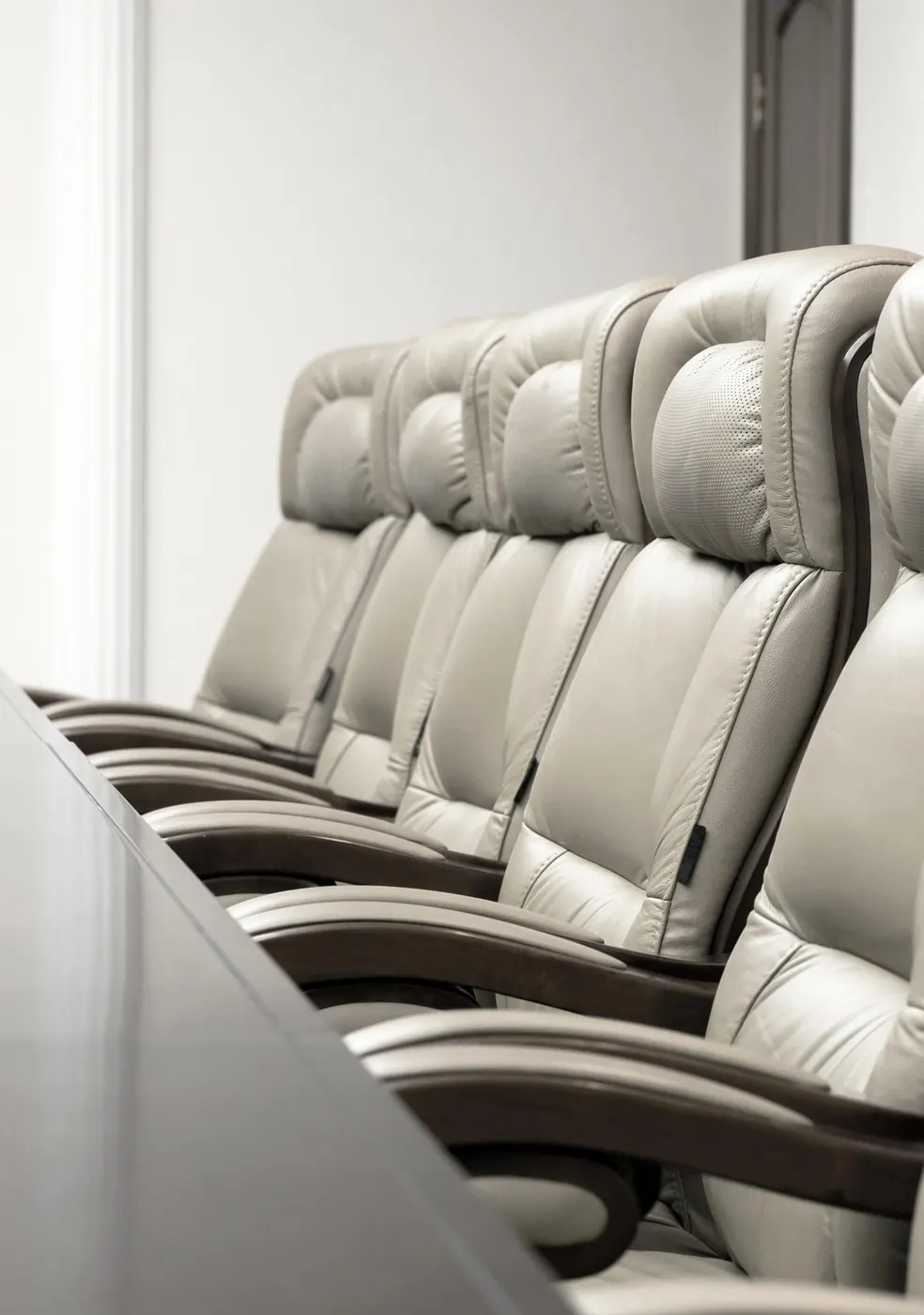 A row of cream leather boardroom chairs