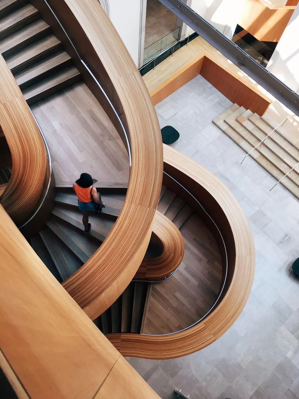 A sweeping timber staircase seen from above, with a person on its path